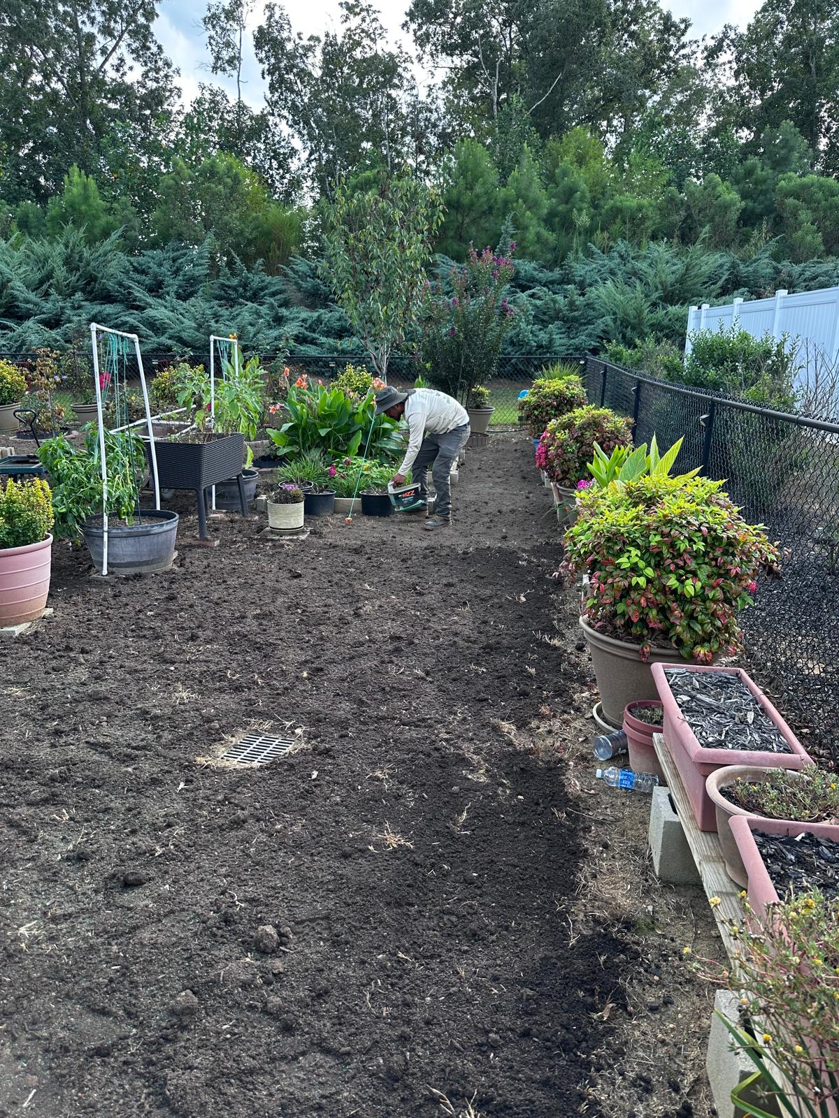 Lawn Bodyguard LLC crew member seeding a freshly tilled backyard garden bed